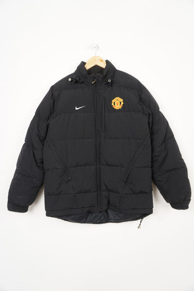 Nike Manchester United black puffer coat with embroidered badge and swoosh detail on the chest