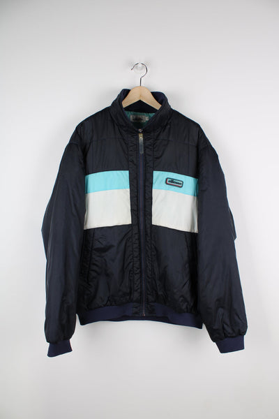Navy blue vintage Ellesse coat. Features puff print logo on the chest and blue and white panels across the chest.