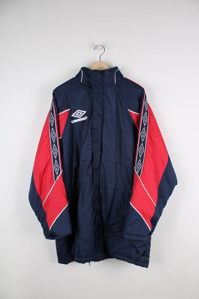Blue and red Umbro coat with embroidered logo on the chest and branded stripe down each arm.