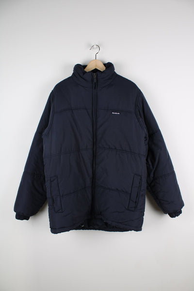Blue Reebok puffer coat with embroidered logo on the chest.