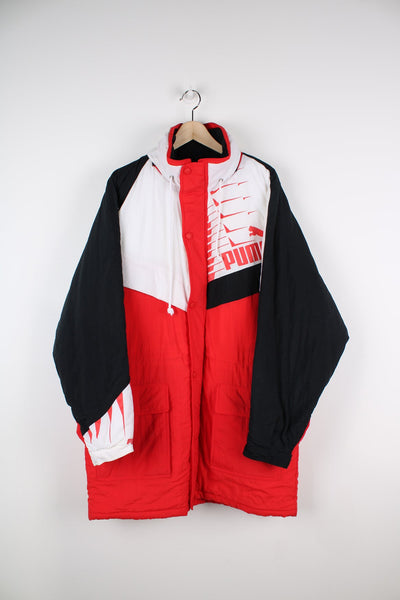 Red, white and black Puma coat with printed logo on the chest and a packaway hood.