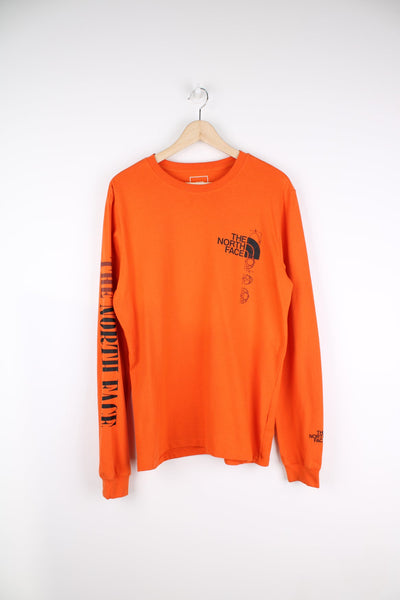 The North Face orange long sleeve T-Shirt with printed logo on the chest and spell out logo down the sleeve.