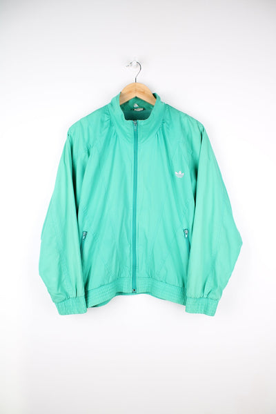 Vintage Adidas green tracksuit jacket featuring embroidered logo on the chest.