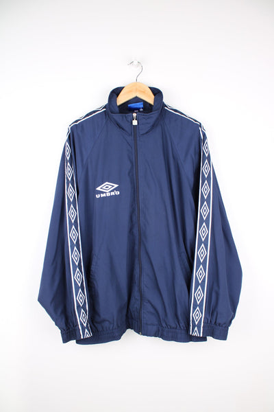 Blue Umbro tracksuit top with embroidered logo on the chest and branded stripe down each sleeve.