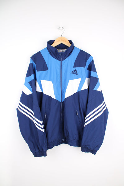 Adidas Le Rosey tracksuit top with blue and white panelling and signature three stripe design. Features embroidered logo on the chest and Le Rosey printed logo on the back. 