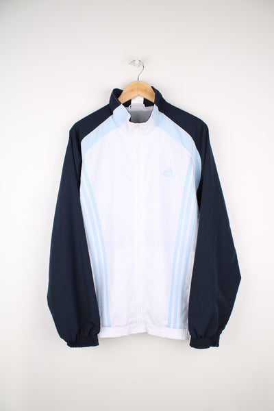 Blue and white Adidas tracksuit top. Features embroidered logo on the chest and signature three stripes.