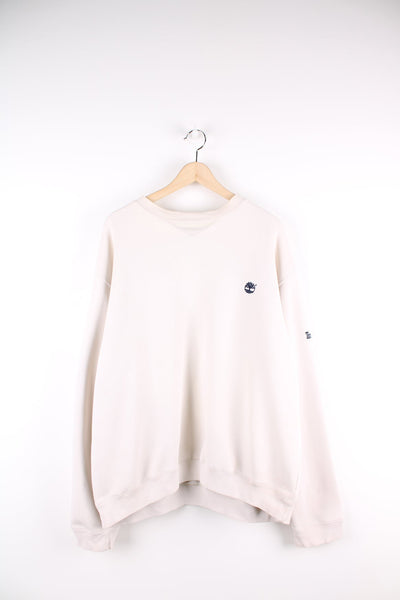 Beige Timberland sweatshirt featuring embroidered logo on the chest and sleeve.
