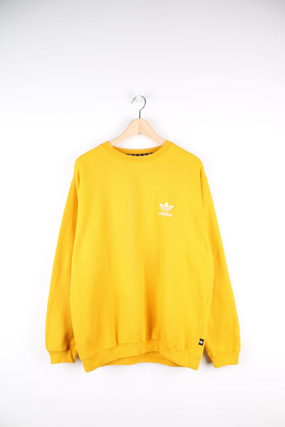 Yellow Adidas sweatshirt with embroidered logo on the chest.