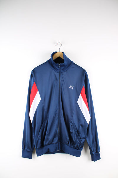Blue Puma tracksuit top with embroidered logo on the chest and red and white panel feature.