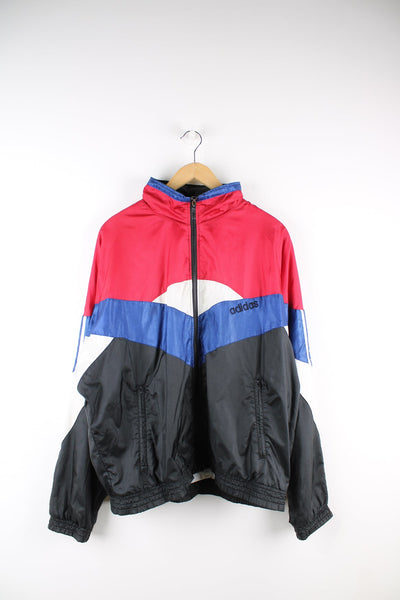 Red and black Adidas tracksuit top with blue panel feature and embroidered logo on the chest.