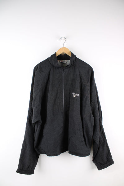 Black Reebok tracksuit top featuring embroidered logo on the chest and back.
