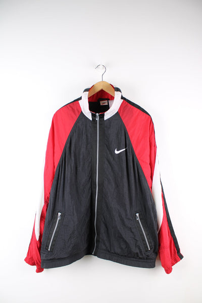 Black and red Nike tracksuit top featuring embroidered logo on the chest and back.
