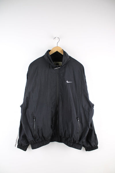 Black Nike tracksuit jacket featuring embroidered logo on the chest and stripe detail down each sleeve.