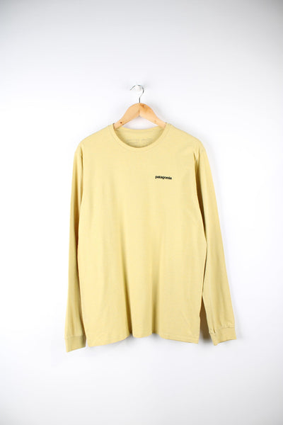 Yellow long sleeve Patagonia top with printed logo on the chest and back.