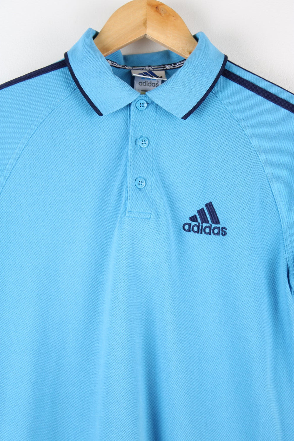 Vintage Adidas polo shirt with embroidered logo on the chest and signature three stripes on each sleeve.