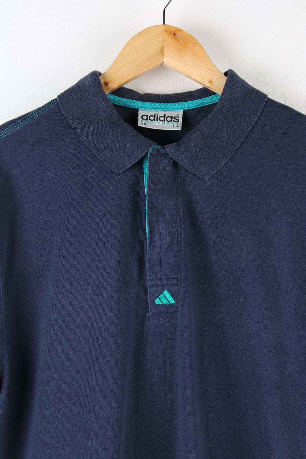 Vintage Adidas polo shirt featuring embroidered logo on the chest and sleeve.