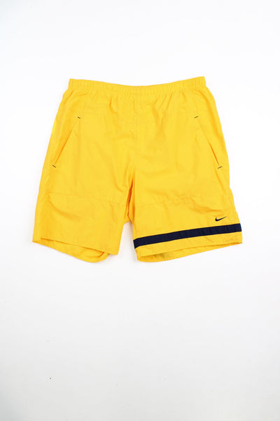Yellow Nike shorts with elasticated drawstring waist, embroidered logo and black panel detailing. 