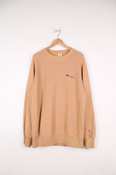 Champion Reverse Weave sweatshirt in light brown/terracotta. Features embroidered logo on the chest and spell out logo across the back.