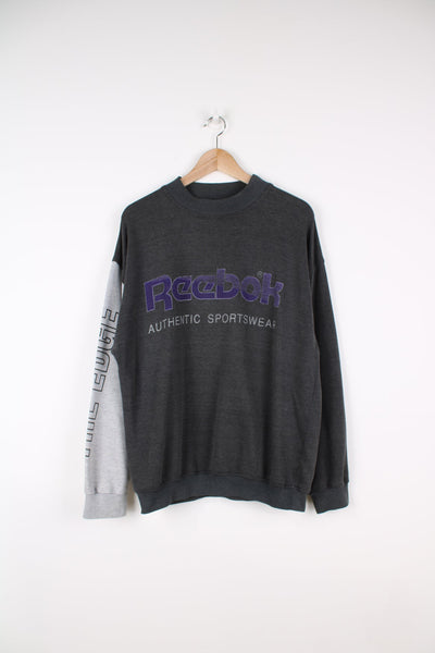 Vintage Reebok sweatshirt with printed logo across the chest in purple.